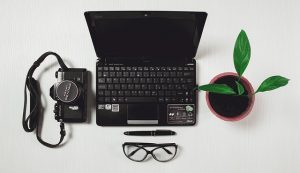 Laptop with camera, glasses and plant
